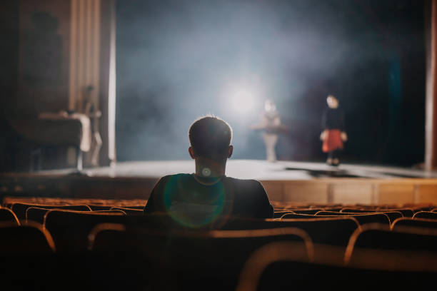 One spectator sitting and watching the rehearsal of ballet dancer on stage